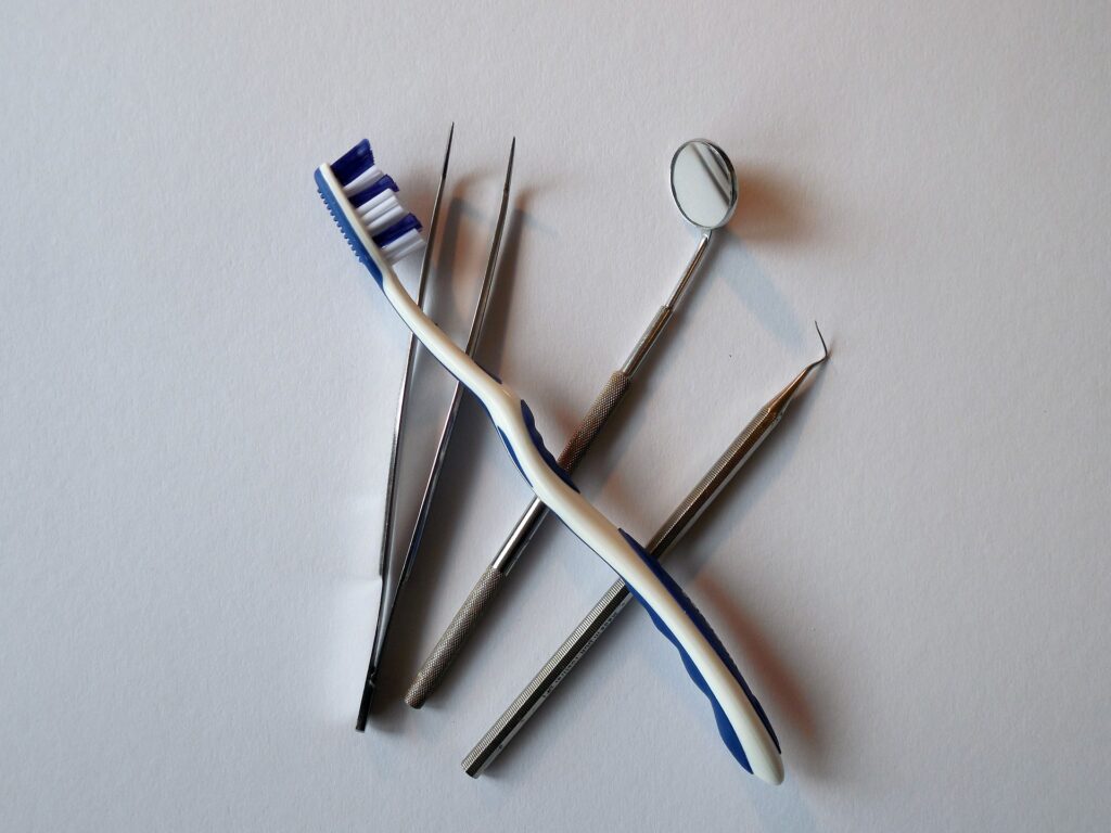 Dental instruments and a toothbrush arranged on a white background. The image shows tools used in general dentistry and oral care. Represents the type of equipment used in the dental office building for sale in Warrior Alabama.